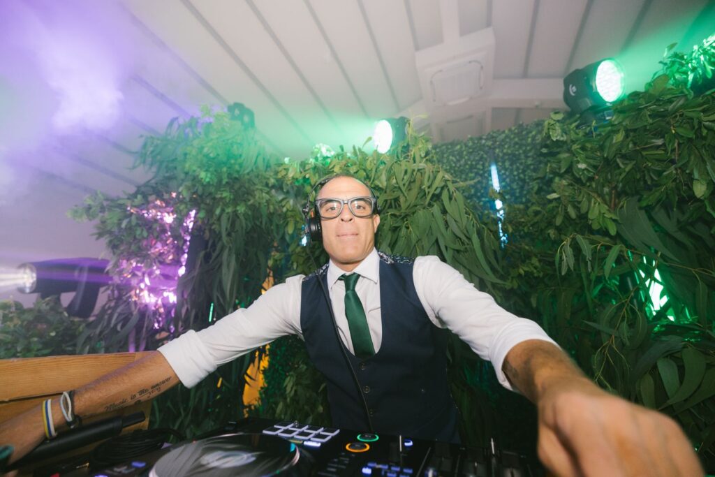 DJ Ronny Díaz en cabina de sonido animando una boda en Tenerife con equipo profesional.