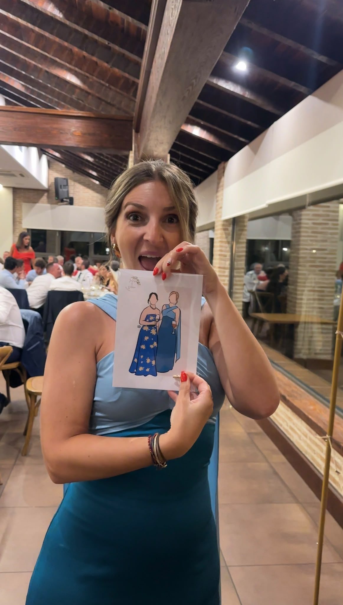 invitada con vestido azul sujetando su ilustración por Andrea Aguado
